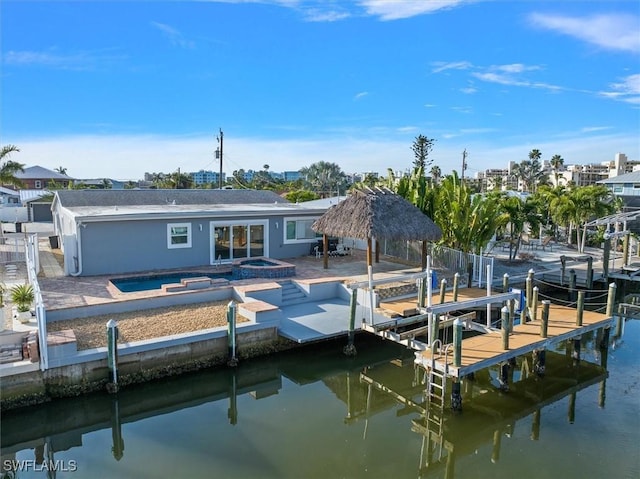 view of dock with a patio area, a swimming pool with hot tub, and a water view