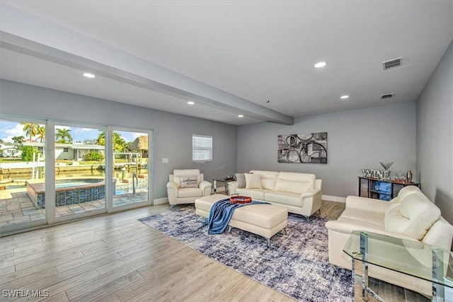 living room featuring light wood-type flooring and beam ceiling