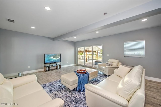 living room with light wood-type flooring and beamed ceiling