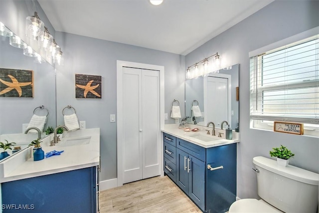 bathroom with toilet, vanity, and hardwood / wood-style flooring