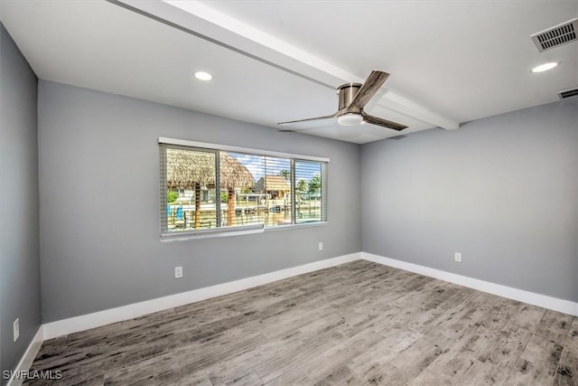 empty room featuring ceiling fan, beamed ceiling, and wood-type flooring