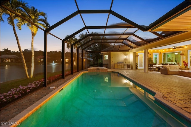 view of swimming pool featuring a lanai, a patio area, an outdoor kitchen, and outdoor lounge area