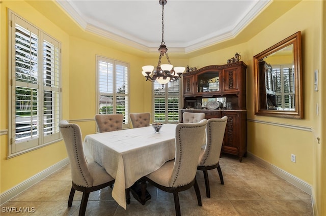 dining space featuring baseboards, a tray ceiling, ornamental molding, and an inviting chandelier