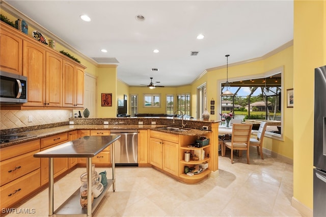 kitchen with a peninsula, a sink, visible vents, ornamental molding, and appliances with stainless steel finishes