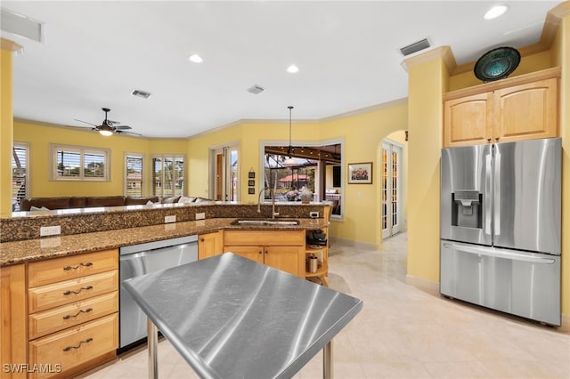 kitchen featuring visible vents, appliances with stainless steel finishes, arched walkways, and a sink