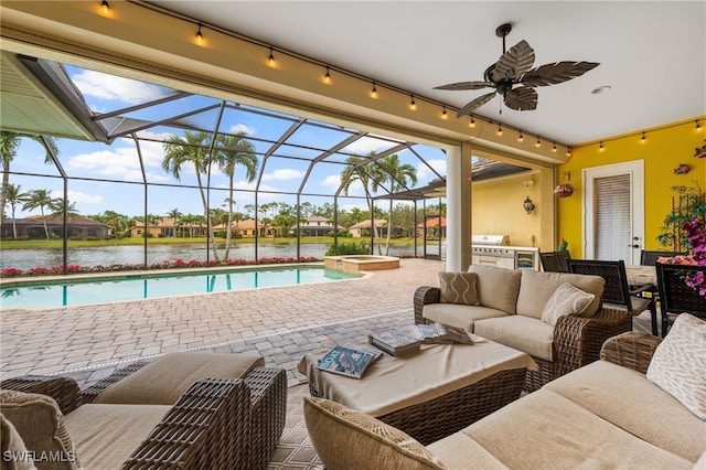 view of pool with a water view, a pool with connected hot tub, ceiling fan, and area for grilling