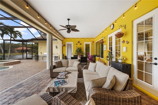 sunroom / solarium with a ceiling fan and french doors