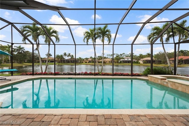 view of pool with a pool with connected hot tub, glass enclosure, and a water view