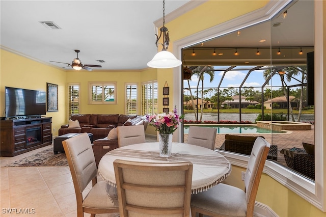 tiled dining room featuring a sunroom, a fireplace, visible vents, and a ceiling fan