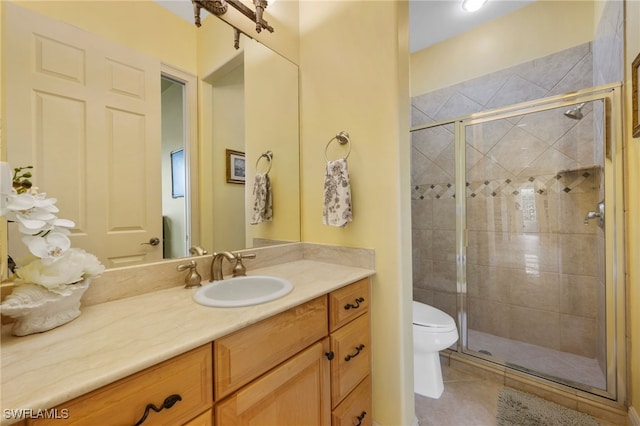 bathroom with vanity, a shower stall, toilet, and tile patterned floors