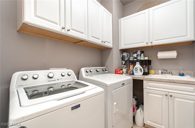 washroom featuring sink, cabinets, and independent washer and dryer