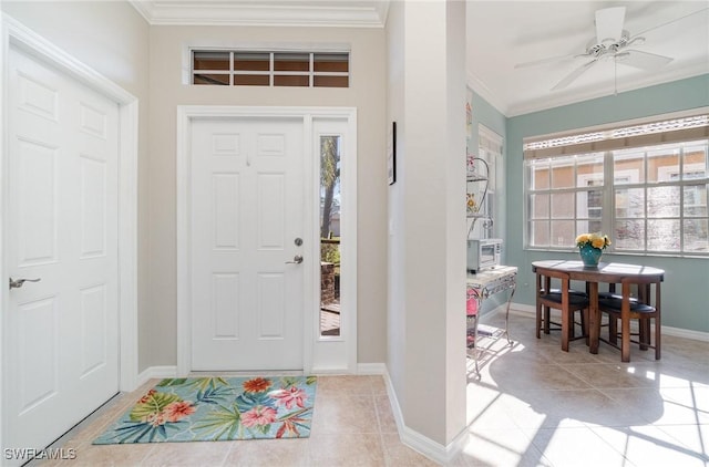 tiled foyer featuring ceiling fan and crown molding