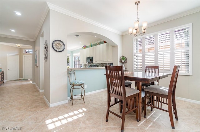 dining room with light tile patterned flooring, ornamental molding, and a notable chandelier