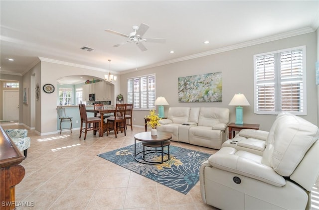 tiled living room with ceiling fan with notable chandelier, ornamental molding, and plenty of natural light