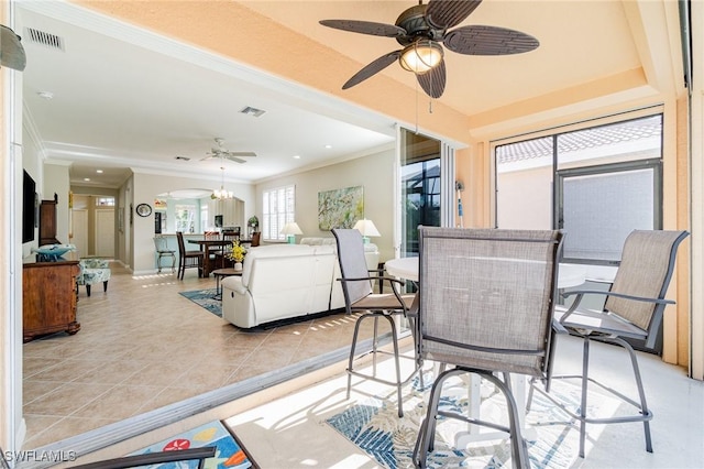 dining space featuring ceiling fan with notable chandelier, light tile patterned floors, and crown molding