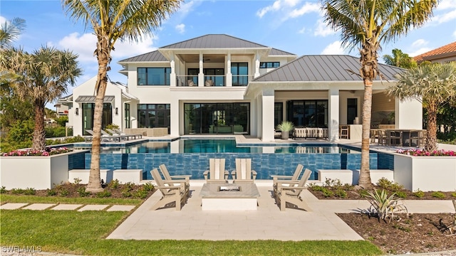 rear view of house with a balcony and a patio area