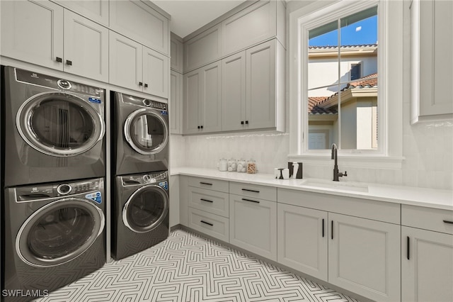 washroom with stacked washer / drying machine and cabinet space