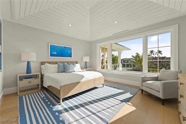 bedroom with wood ceiling and light hardwood / wood-style floors