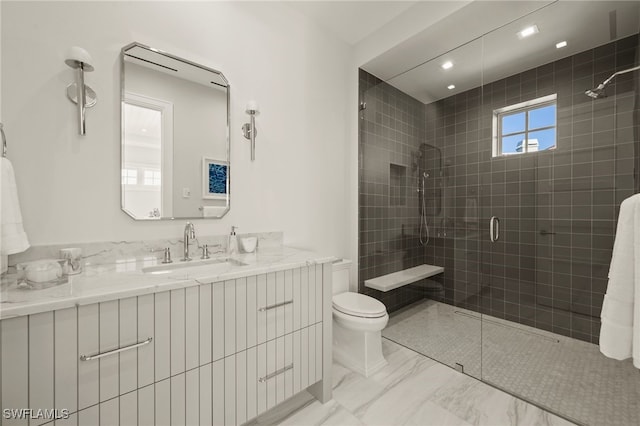 bathroom featuring a tile shower, toilet, marble finish floors, vanity, and recessed lighting