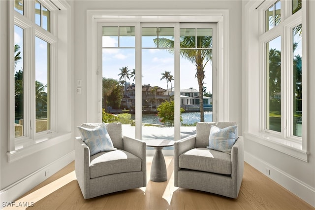 sunroom featuring a healthy amount of sunlight and a water view