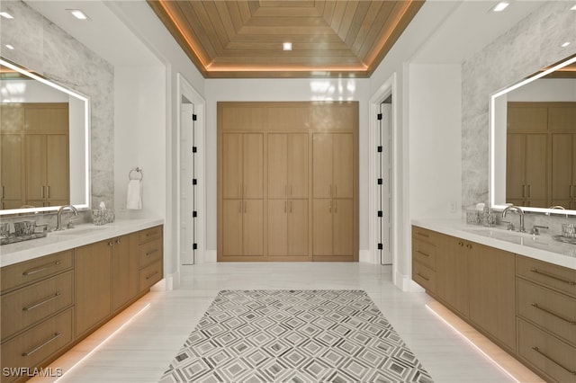 bathroom with a raised ceiling, backsplash, and two vanities