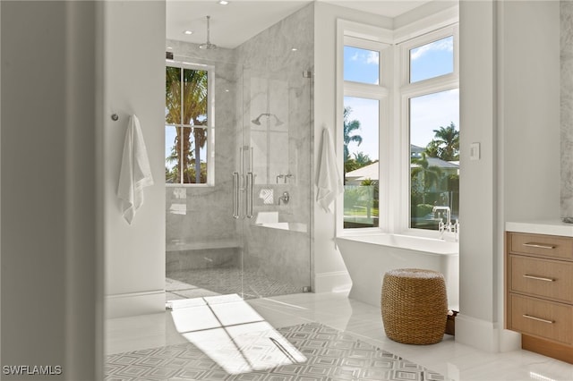 bathroom with a shower stall, tile patterned floors, a freestanding tub, and vanity