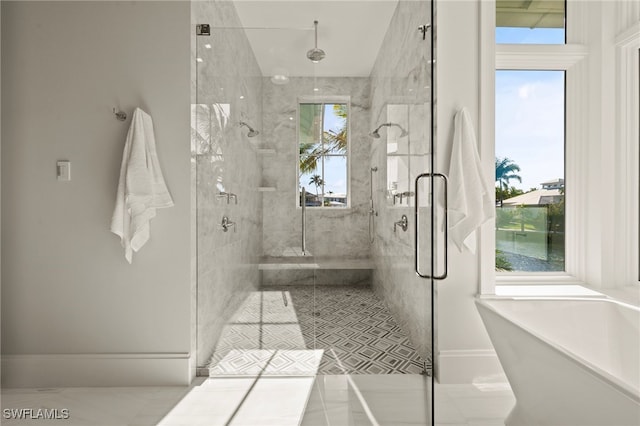 full bath featuring a marble finish shower, a freestanding tub, and tile patterned flooring