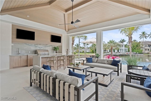 view of patio featuring a grill, outdoor lounge area, an outdoor kitchen, and a ceiling fan