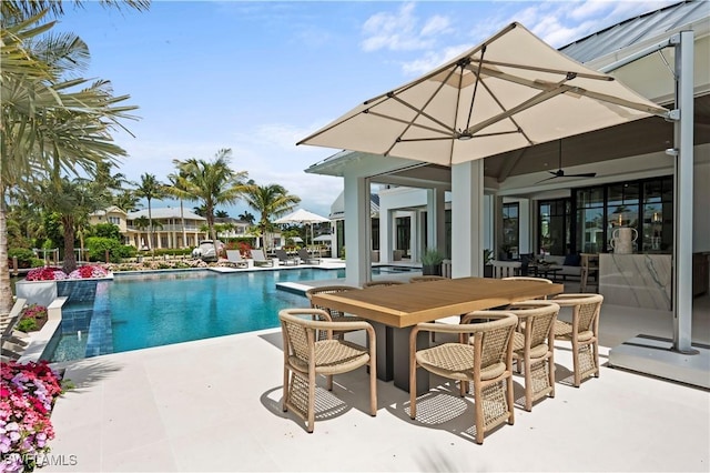 swimming pool featuring a patio, a ceiling fan, and outdoor dining space