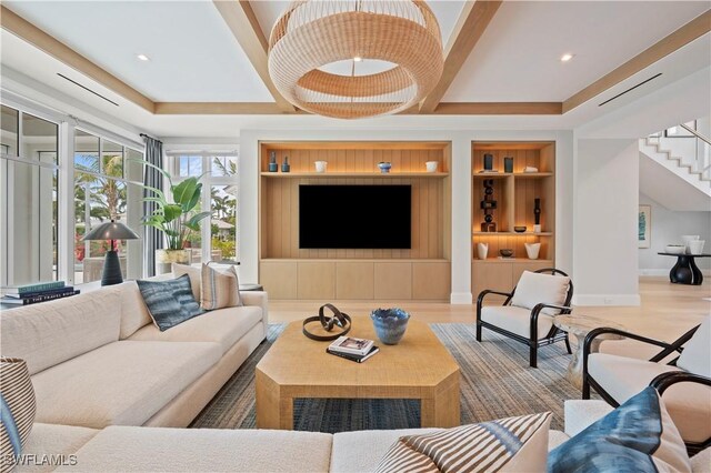 living area featuring built in shelves, stairs, wood finished floors, and baseboards
