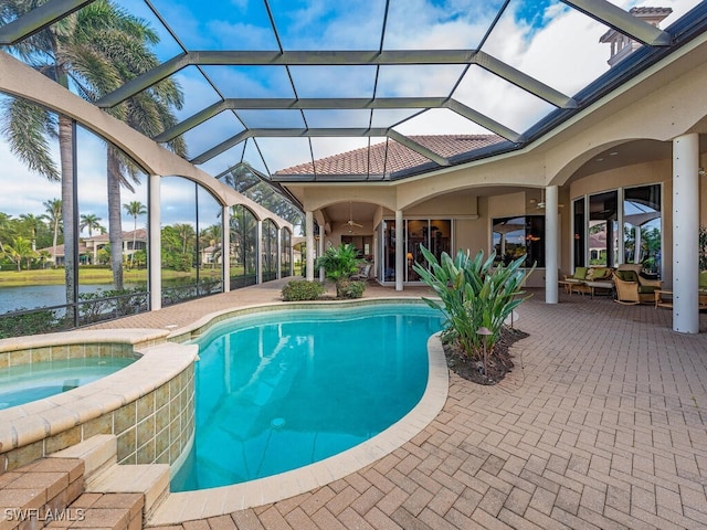 view of swimming pool featuring an in ground hot tub, a water view, glass enclosure, and a patio area