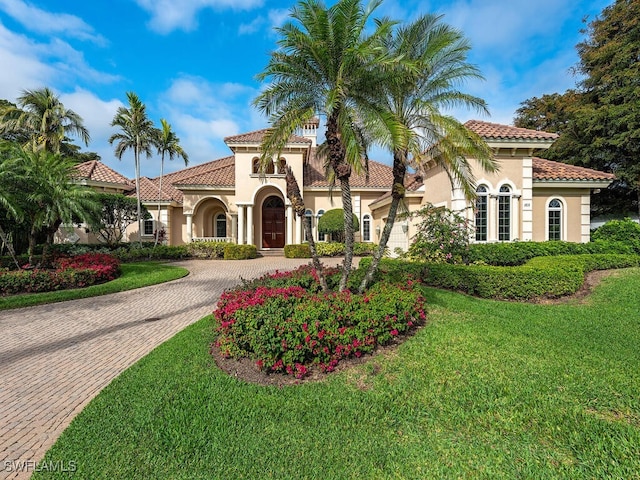 mediterranean / spanish home featuring a front lawn