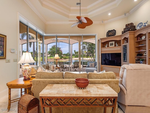 living room with ceiling fan, ornamental molding, a tray ceiling, and a towering ceiling