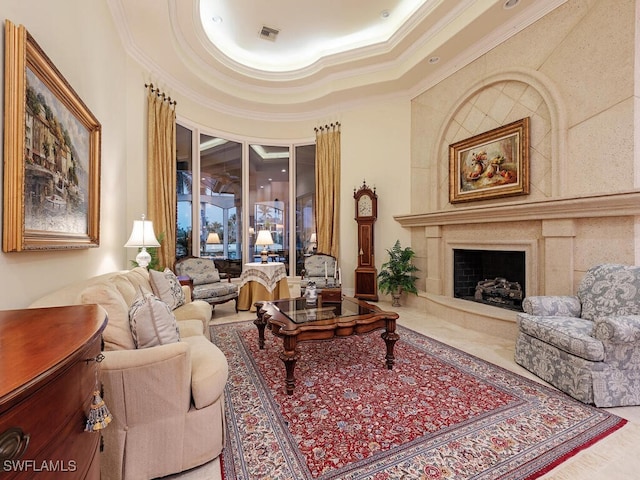 living room with crown molding, a towering ceiling, a high end fireplace, and a tray ceiling