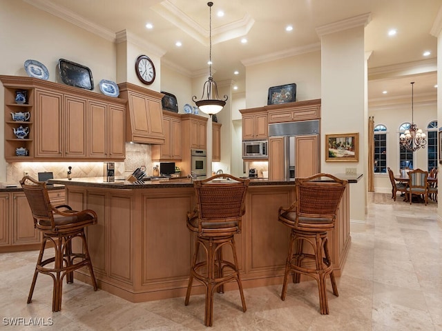 kitchen featuring ornamental molding, built in appliances, a kitchen breakfast bar, and decorative light fixtures