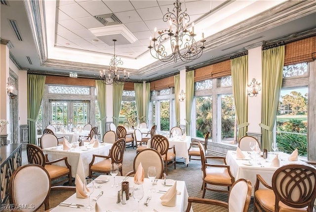 sunroom / solarium featuring a healthy amount of sunlight, a raised ceiling, french doors, and a chandelier