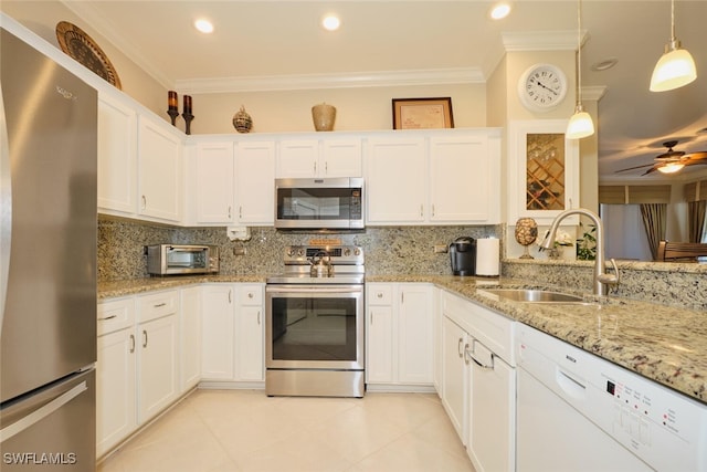 kitchen featuring appliances with stainless steel finishes, pendant lighting, tasteful backsplash, and sink