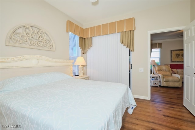 bedroom featuring lofted ceiling, ornamental molding, and dark wood-type flooring