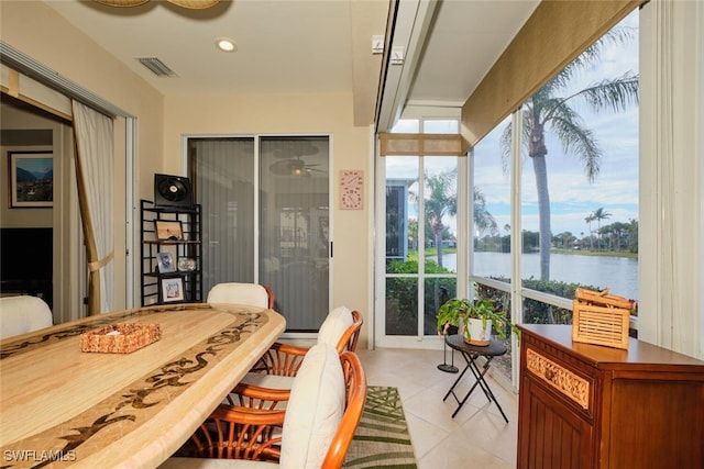 sunroom featuring a water view