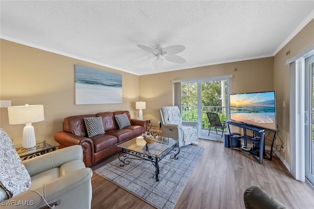 living room featuring ceiling fan, crown molding, a textured ceiling, and light hardwood / wood-style floors