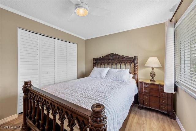 bedroom with ceiling fan, light wood-type flooring, a closet, a textured ceiling, and crown molding