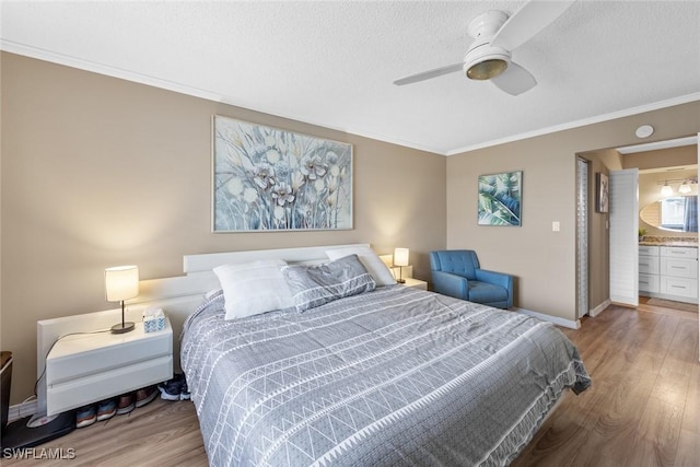 bedroom with ceiling fan, ensuite bath, light hardwood / wood-style flooring, a textured ceiling, and ornamental molding