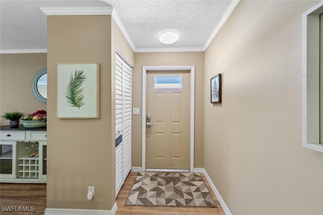 doorway to outside with a textured ceiling, crown molding, and hardwood / wood-style flooring