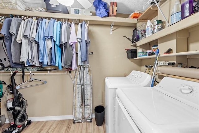 washroom featuring washing machine and dryer, a textured ceiling, and light hardwood / wood-style flooring