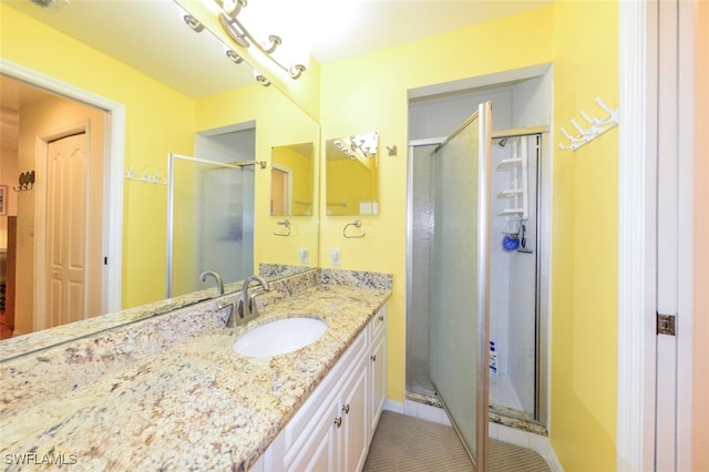 bathroom featuring an enclosed shower, vanity, and tile patterned flooring