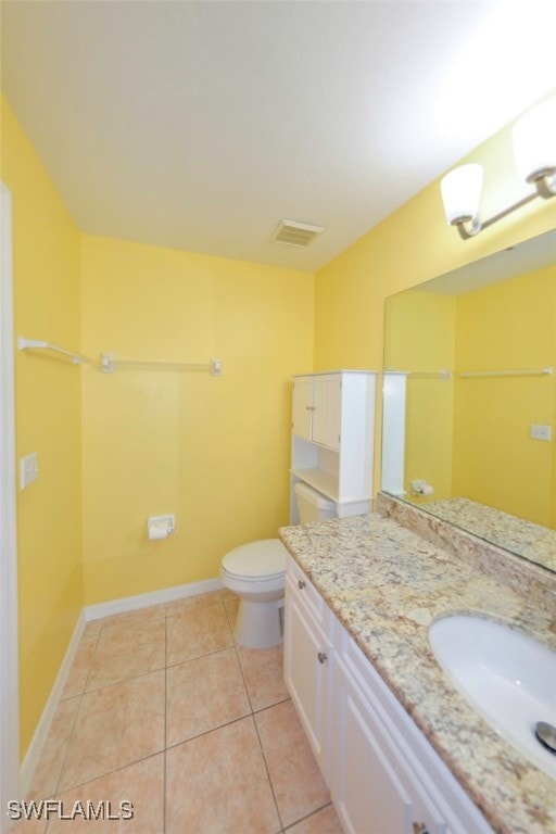 bathroom featuring vanity, tile patterned floors, and toilet