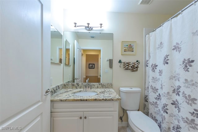 bathroom featuring vanity, toilet, and curtained shower