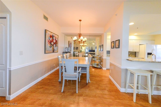 dining room with an inviting chandelier and light wood-type flooring