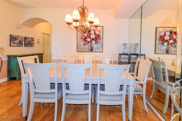 dining space featuring a notable chandelier and light hardwood / wood-style floors