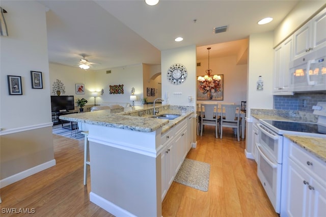 kitchen with sink, white cabinets, and range with two ovens